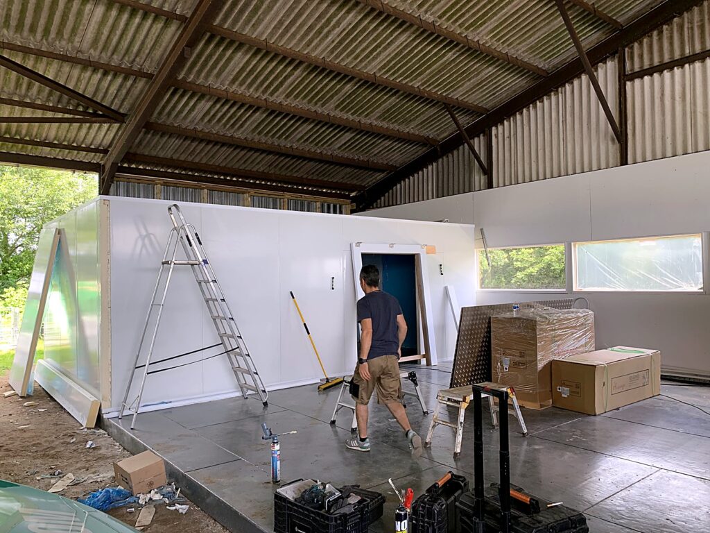 Cold room being built under a farm barn canopy