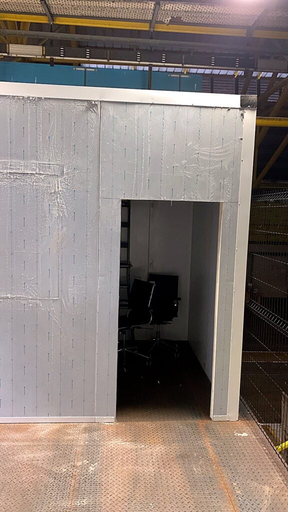 Cold room shell with door opening in a warehouse