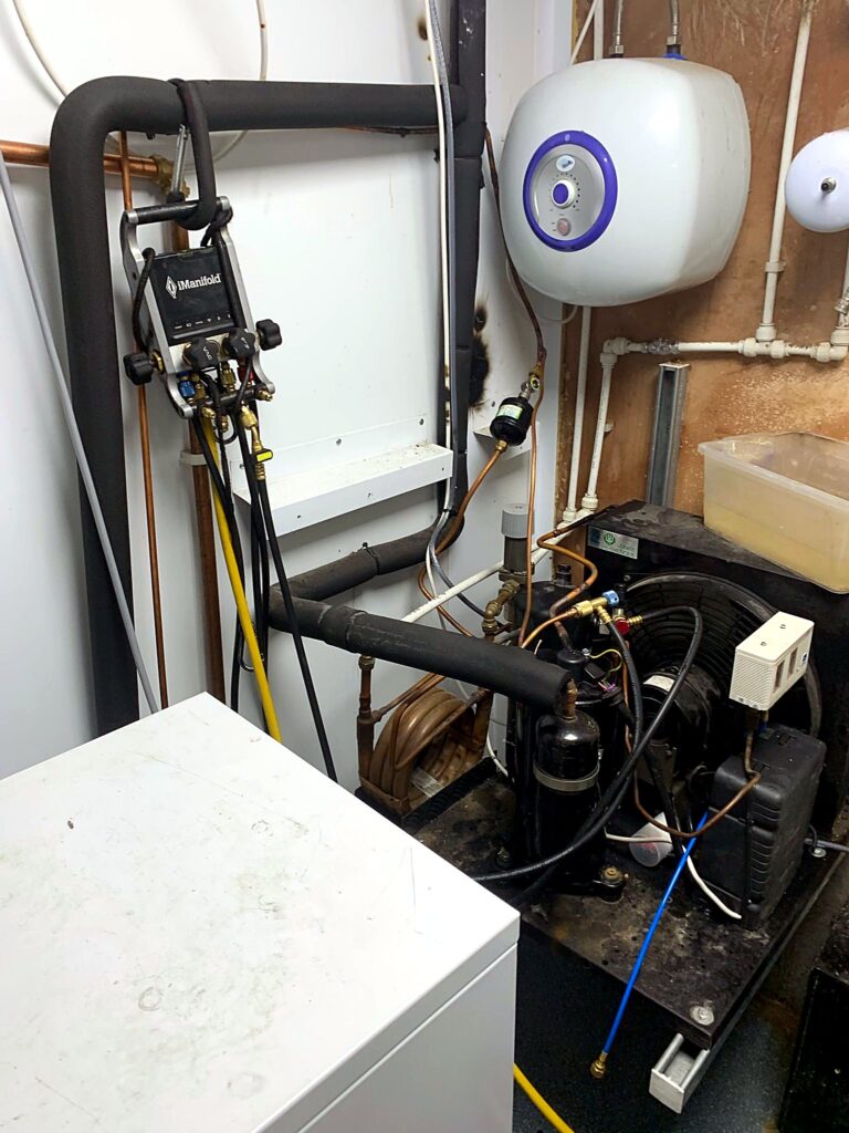 Refrigeration condensing unit installed beside a water heater