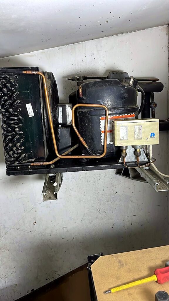 Condensing unit mounted on a wall bracket