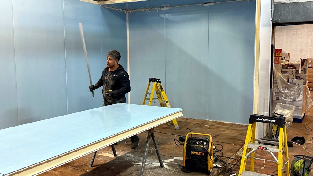 Engineers assembling cold room panels in the workshop