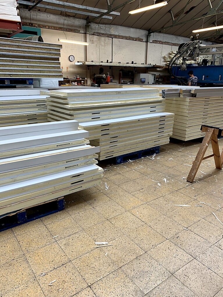 Stacks of insulated cold room panels in the workshop